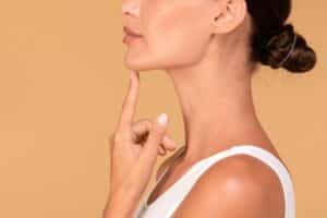 Close up of woman’s profile with slim chin and defined jawline from chin liposuction.