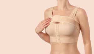A cropped shot of a woman wearing a supportive bra after breast augmentation