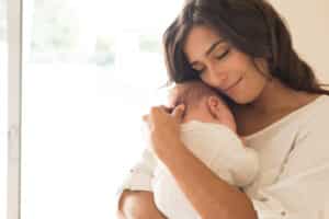 Beautiful woman hugs her baby. Pregnancy was hard on her body but so rewarding.